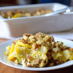 a white plate topped with food next to a casserole dish on a table