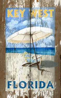 a wooden sign with an umbrella and chair on the beach in front of it that says key west florida