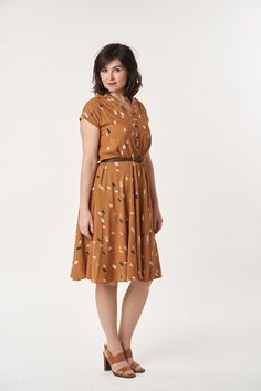 a woman in a brown dress standing on a white background