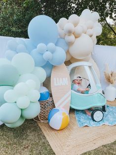 an image of a baby in a car surrounded by balloons and other items on the ground