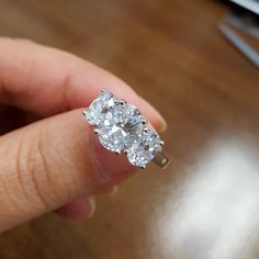 a woman's hand holding a diamond ring