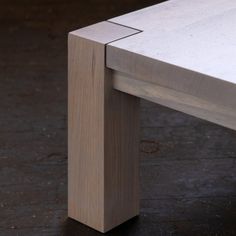 a close up of a wooden bench on a black floor with no one around it