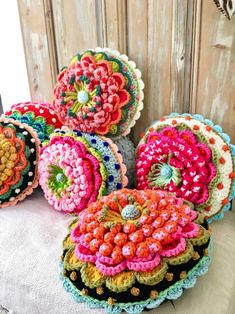 colorful crocheted pillows are on a table