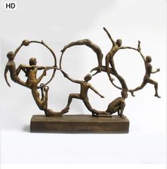 a bronze sculpture depicting three men doing different things with their hands in the air and holding onto each other's arms