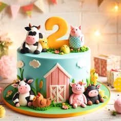 a birthday cake decorated with farm animals and the number two on it's top