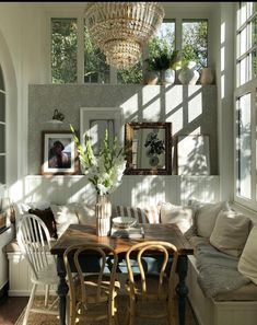 the sun shines through the windows in this dining room with white walls and chairs