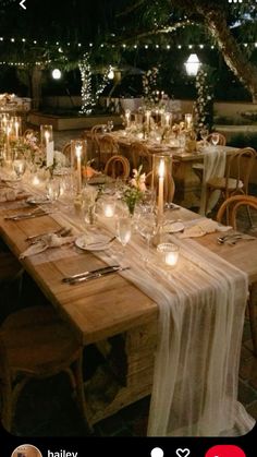 a long table set up with candles and place settings for an outdoor dinner or party