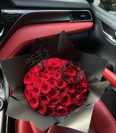 a bouquet of red roses sits in the center of a car