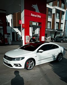 a white car parked in front of a gas station