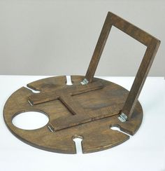 a wooden object with holes in the middle on a table top, sitting on a white surface