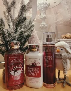 three different types of hand sanitizers sitting on a table next to a christmas tree