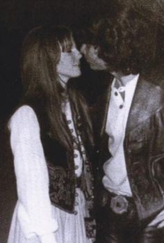 an old black and white photo of two people kissing