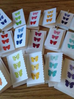 many different colored butterflies are on white cards