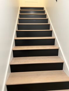 there is a set of stairs with black and white steps on the bottom one side