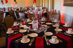 the table is set for an event with red and black linens