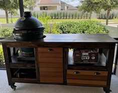 an outdoor bbq grill on top of a wooden table next to a large window