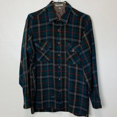 "Mens M by Winterweights Acrylic 44\" chest 27\" length Vintage 70s dark green plaid shirt with green and red pattern-- rustic and classic, perfect for fall or winter. There is some wear, some tearing on the lining at the back of the neck- not visisble when worn. One missing button on the pocket and some loose threads and two spots near the bottom hem- still has lots of life left. See photos closely." Green Flannel Shirt For Winter, Classic Green Flannel Shirt For Fall, Vintage Long Sleeve Flannel Shirt, Vintage Green Cotton Flannel Shirt, Vintage Plaid Shirt With Snap Buttons, Green Plaid Shirt, Vintage Button-up Flannel Shirt With Pockets, Vintage Flannel Button-up Shirt With Pockets, Vintage Numbers