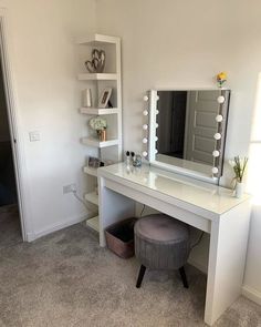 a white vanity table with a mirror and stool