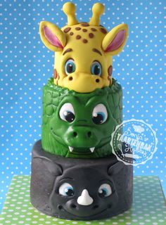 a three tiered cake decorated to look like a giraffe and an alligator