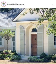 a house with white trim and shutters on the front door is seen in this image