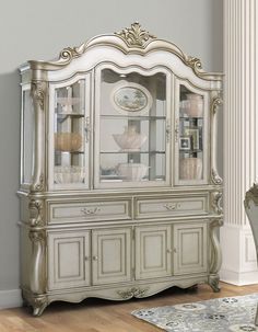 a white china cabinet with glass doors and drawers in a room next to a rug