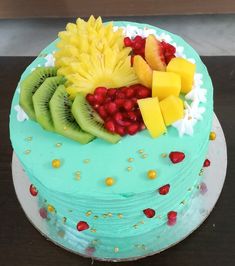 there is a blue cake with fruit on it