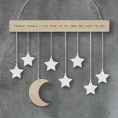 a wooden star and moon mobile hanging from a metal rod with the words twinkle twinkle little star, do you know how loved you are?