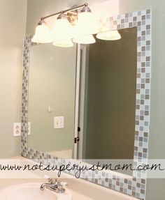 a bathroom sink sitting under a mirror next to a wall mounted faucet with lights on it