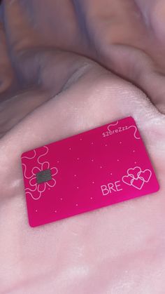 a pink credit card sitting on top of a bed