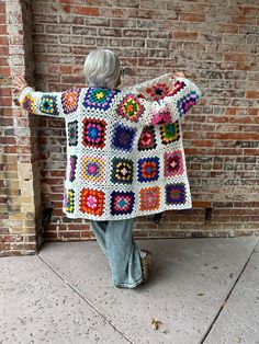 Be the granniest chic around in this hand crocheted duster cardigan – literally the square of fashion! This one-of-a-kind piece is made of cotton yarn with colorful squares on a white background, and it has an oversized fit. You won't be able to wait to show off your style with this fun and unique look! One Size fits most M-XL. White Granny Square Cardigan For Spring, Multicolor Granny Square Cardigan For Spring, White Bohemian Cardigan With Granny Square, White Long Sleeve Cardigan With Granny Squares, Bohemian White Outerwear With Granny Square Details, White Bohemian Hand Knitted Outerwear, Bohemian White Outerwear With Granny Square, White Crochet Cotton Outerwear, White Cotton Crochet Outerwear