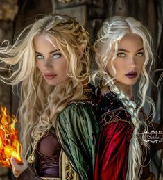 two beautiful blonde women dressed in medieval clothing holding fireballs and looking at the camera