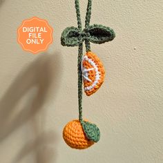 a crocheted orange hanging from a string