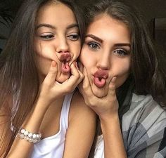 two young women making funny faces with their hands