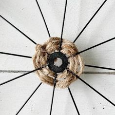 an overhead view of a white umbrella with black spokes and rope wrapped around it