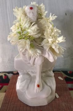 a white vase filled with flowers on top of a table