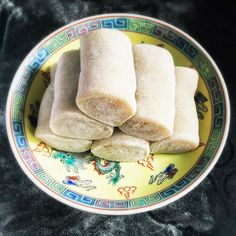 three pieces of food on a yellow and blue plate with black table cloth in the background