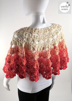 a white mannequin wearing a red and beige crochet shawl