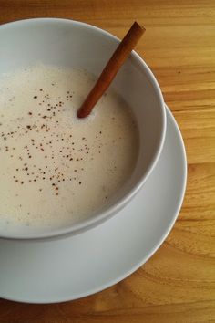 a white bowl filled with liquid and cinnamon sticks