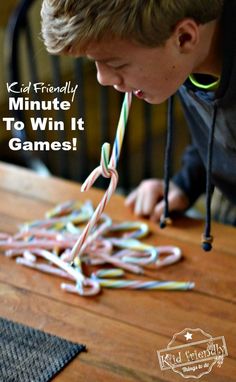 a young boy blowing out some candy canes on top of a wooden table with the words, kid friendly minute to win it games