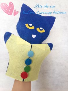 a hand with a blue cat on it's arm and some pom poms