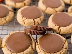 peanut butter cookies cooling on a rack with chocolate frosting in the middle and one half eaten