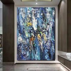 an abstract painting hangs on the wall next to a sink in a large room with marble floors