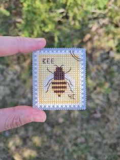 a person holding up a tiny needled bee on a piece of cloth with the words keep bees in it