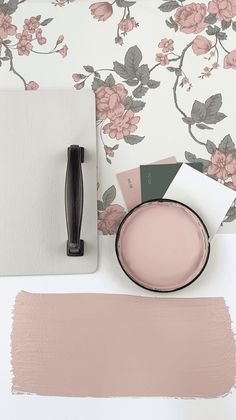 a table topped with pink paint next to a wallpaper