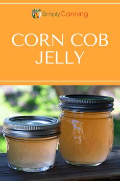 two jars filled with corn cob jelly sitting on top of a wooden table