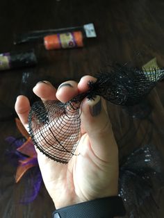 a person holding something in their hand on a table with other items around them and some sort of wire