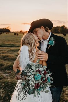 a bride and groom kissing in the field