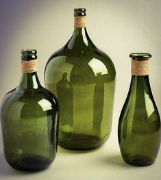 three green glass bottles sitting next to each other