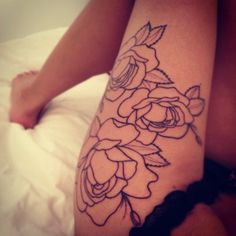 a woman's leg with flowers tattooed on it