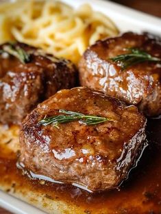 some meatballs and pasta on a white plate